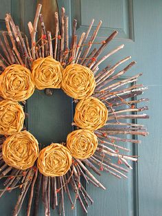 a wreath made out of sticks with yellow flowers on the front and side of it