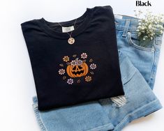 This is a Comfort Colors garment-dyed embroidered Halloween pumpkin t-shirt; a cute spooky tee made 100% with ring-spun cotton. The soft-washed, garment-dyed fabric brings extra coziness to your wardrobe while the relaxed fit makes it an excellent daily choice. The double-needle stitching throughout the embroidered jack-o-lantern tee makes it highly durable while the lack of side-seams helps this cute fall gift for her shirt retain its tubular shape. .: 100% ring-spun cotton .: Medium fabric (6. Black Embroidered T-shirt For Fall, Black Embroidered Tops For Halloween, Embroidered Black T-shirt For Fall, Embroidered Halloween, Embroidered Tee, Pumpkin Shirt, Fall Shirt, Fall Sweatshirt, Dyed Fabric