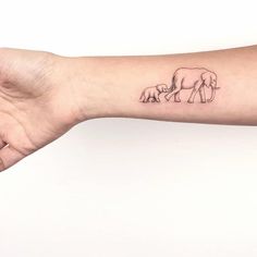 an elephant and her baby tattoo on the arm