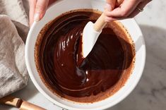 someone is spreading chocolate in a bowl with a spatula