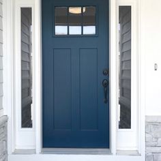 a blue front door with two sidelights on the top and bottom windows above it