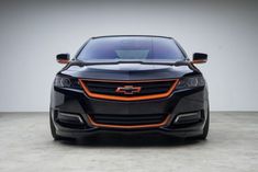 the front end of a black and orange car