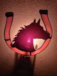 a light that is on the wall with a horse's head painted on it