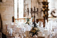 the table is set with white linens and place settings for guests to sit at