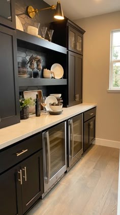 a kitchen with black cabinets and white counter tops