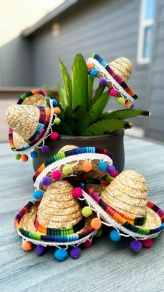 a potted plant sitting on top of a wooden table covered in colorful bracelets