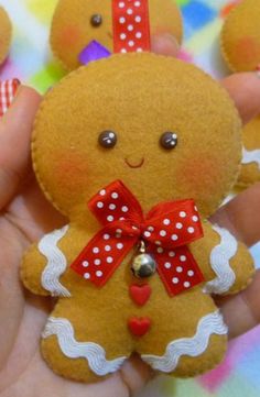 a hand holding a small ginger doll with red and white polka dots on it's chest