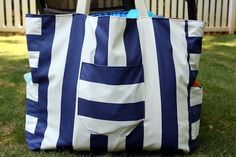 a large blue and white striped bag sitting in the grass