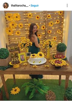 a woman standing in front of a table with sunflowers and cakes on it