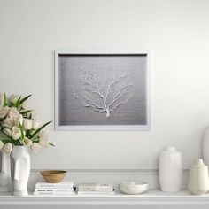 a white mantle with vases and flowers on it, along with a framed photograph