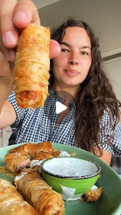 a woman holding up a piece of food in front of her face