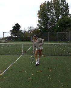 a woman standing on top of a tennis court holding a racquet in her hand