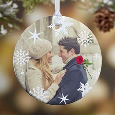 an ornament hanging from a christmas tree decorated with snowflakes and stars