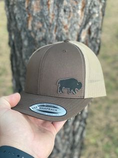 "Design: Bison Hat Looking for that special gift? Each hat is made to order just for you and/or loved one! Please don't hesitate to contact us for custom requests or wholesale information. Sign Up For Our Newsletter At: www.BlackHillsWildwoods.com  FEATURES  * Yupoong 6606 Adult Six Panel Adjustable Snapback Hat With Leatherette Patch * Hat Color Options: Brown/Khaki, Navy/Silver, Marron/Grey, Charcoal/Black, Moss/Khaki & Grey/Black (Please see the photo slide for color samples.) * 65/35 Polyest Brown Flat Bill Baseball Cap For Gift, Brown Cap For Outdoor Activities, Brown Outdoor Hat With Curved Bill, Brown Baseball Cap As A Gift, Brown Curved Bill Hat For Outdoor Activities, Adjustable Brown Flat Brim Dad Hat, Brown Flat Brim Dad Hat, Brown Flat Bill Hat As Gift, Gift Brown Flat Bill Hat