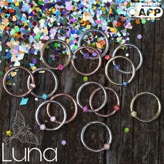 a bunch of metal rings sitting on top of a wooden table covered in confetti