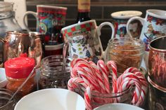 candy canes, mugs and other christmas items are on the kitchen counter top