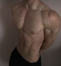 a man with no shirt on posing for the camera, showing off his muscular back