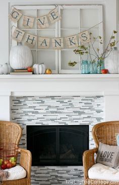 two wicker chairs in front of a fireplace with a sign that says give thanks