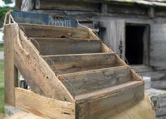 an old wooden structure with steps leading up to it