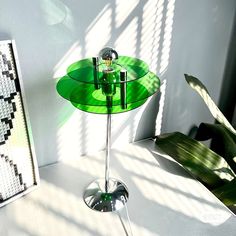 a table with a green plate on it next to a plant