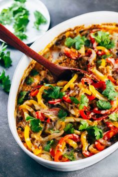 a white bowl filled with mexican food and garnished with fresh cilantro