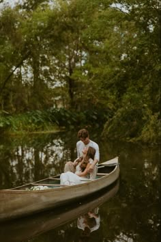 a man and woman are sitting in a small boat on the water while holding each other