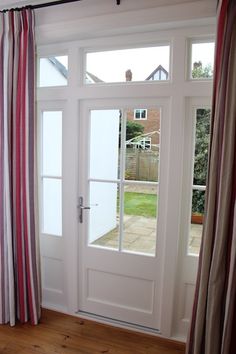 an open door with striped curtains in front of it and a window to the outside