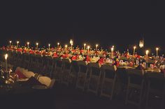 a long table with many chairs and candles in the middle is set up for an event