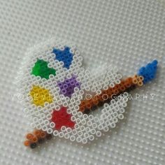 a cross stitch beaded brooch with colorful beads on it's back side