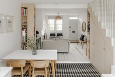 a living room and dining area with black and white checkered flooring