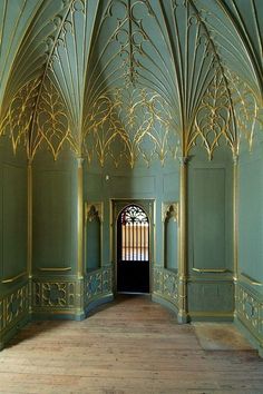 an ornate hallway with green walls and gold trim on the ceiling is pictured in this image