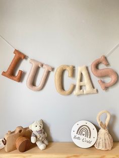 a wooden shelf topped with stuffed animals and letters that spell out the word utca's