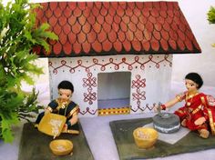 two small figurines sitting on top of cement blocks next to a potted plant