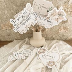 a vase filled with paper cutouts sitting on top of a white cloth covered table