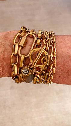 A multi-row chain bracelet, this piece features three strands of varying chain links. Modern and chic, this gold bracelet also features a pave lobster clasp that adds interest and detail to its design. Wear this multi-strand gold bracelet when you want to bring a contemporary touch to your look. Truly perfect all by itself or layered with other lengths and textures to create your statement look. Length: 7 ½-8 ½" The chain is 14K gold plated over brass with a burnished finish The clasp is an easy Luxury Gold-plated Chain Bracelet With Charms, Elegant Gold-tone Chunky Chain Bracelet, Luxury Gold-tone Statement Chain Bracelet, Gold-tone Gold Plated Chain Link Charm Bracelet, Gold-tone Metal Link Charm Bracelet, Stacked Jewelry, Strand Bracelet, Gold Bracelet Chain, Crystal Charm