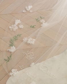 a bride's veil and flowers on the floor with her name written on it