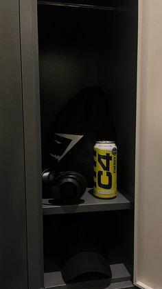 a can of beer sitting on top of a shelf next to a baseball cap and glove