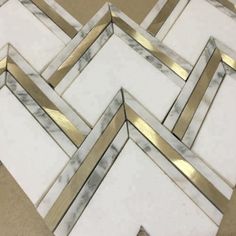 some white marble and gold trimmings on top of a brown flooring area