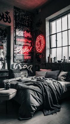 a bed sitting under a window next to a neon sign