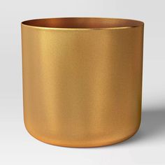 a gold colored metal bowl on a white background