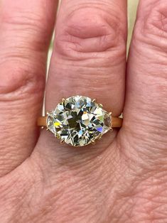 a woman's hand holding an engagement ring with two diamonds on it, and the middle