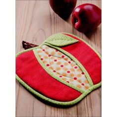 an apple sitting on top of a wooden table next to a piece of cloth and some apples