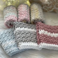 four crocheted blankets laying on top of a bed