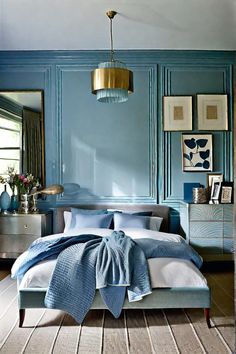 a bedroom with blue walls and white bedding