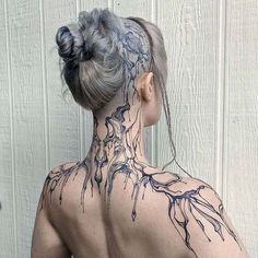 a woman with tattoos on her back and neck