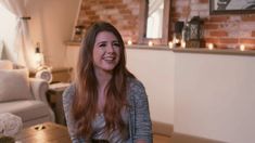 a woman is smiling while standing in the living room