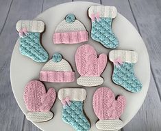 decorated cookies on a plate with mittens and gloves