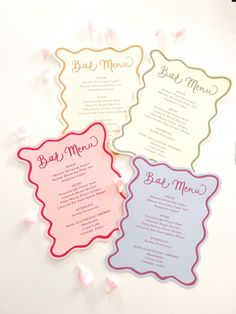 three different colored menu cards on a table