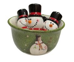 three snowmen in a green bowl with black tops