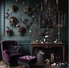 a living room with green walls and purple chairs in front of a table filled with candles